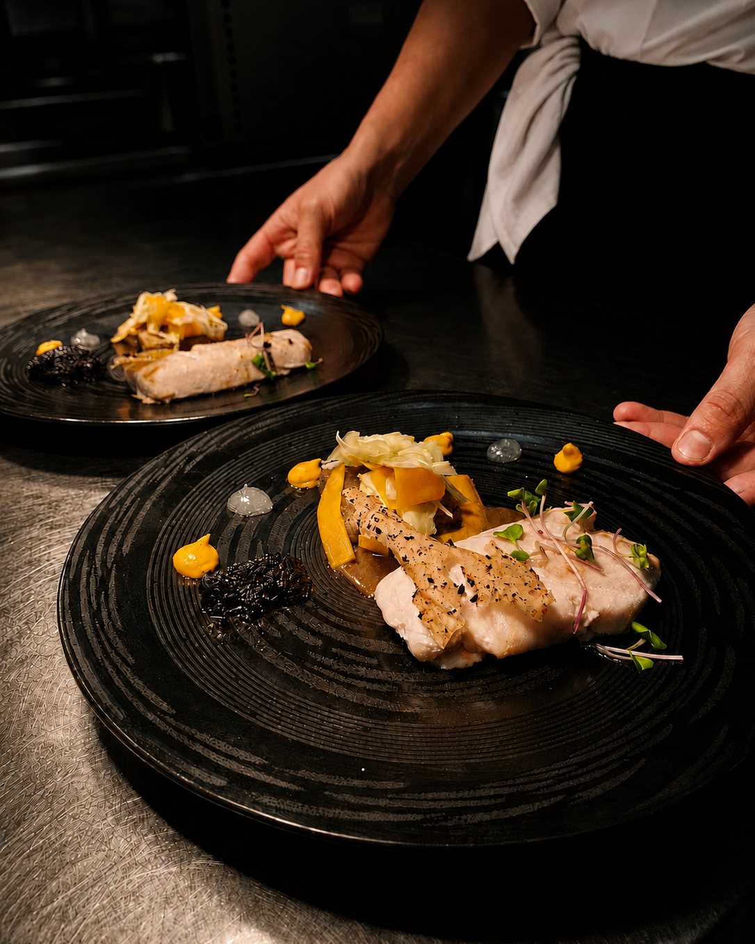 Deux assiettes dressées sur le passe, prêtes à partir en salle