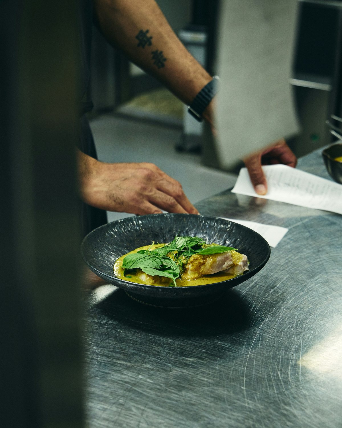 Un chef dresse une assiette, le geste précis