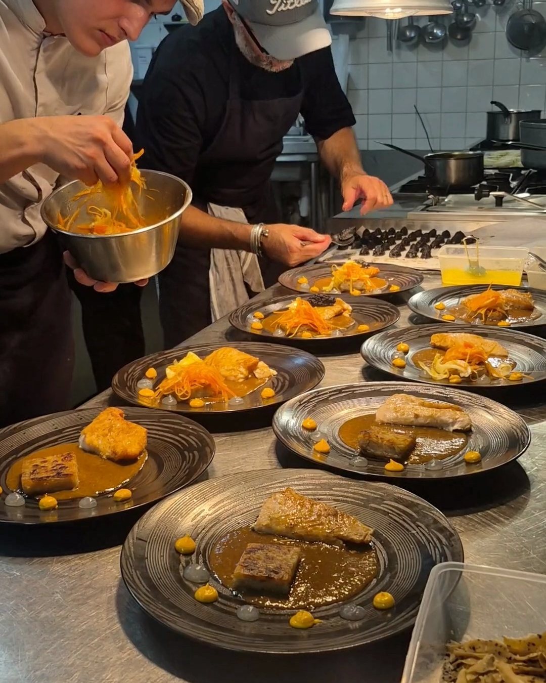 Deux chefs de la Brigade dressent une série d’assiettes