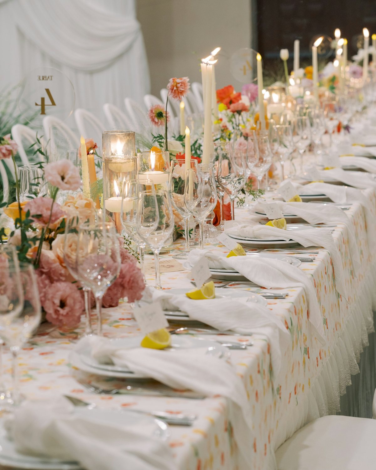 Une longue table de mariage dressée, éclairée aux bougies